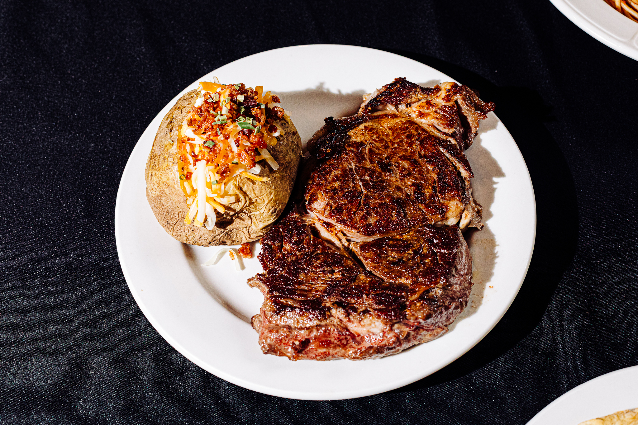 Owner Alfie Cascio said the ribeye, which is Angus beef, is a newer addition to the steak menu. It is served with both a loaded baked potato and a side of pasta at Omaha’s last Italian steakhouse.<br />(Joshua Foo / Flatwater Free Press)