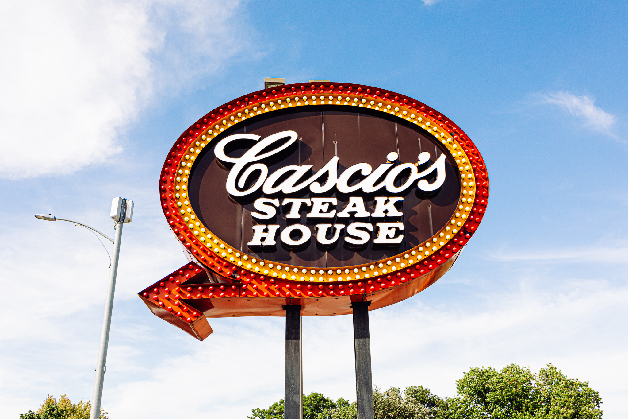 An old-school glowing sign marks the location of Cascio’s, in Omaha’s Little Italy neighborhood.<br />(Joshua Foo / Flatwater Free Press)