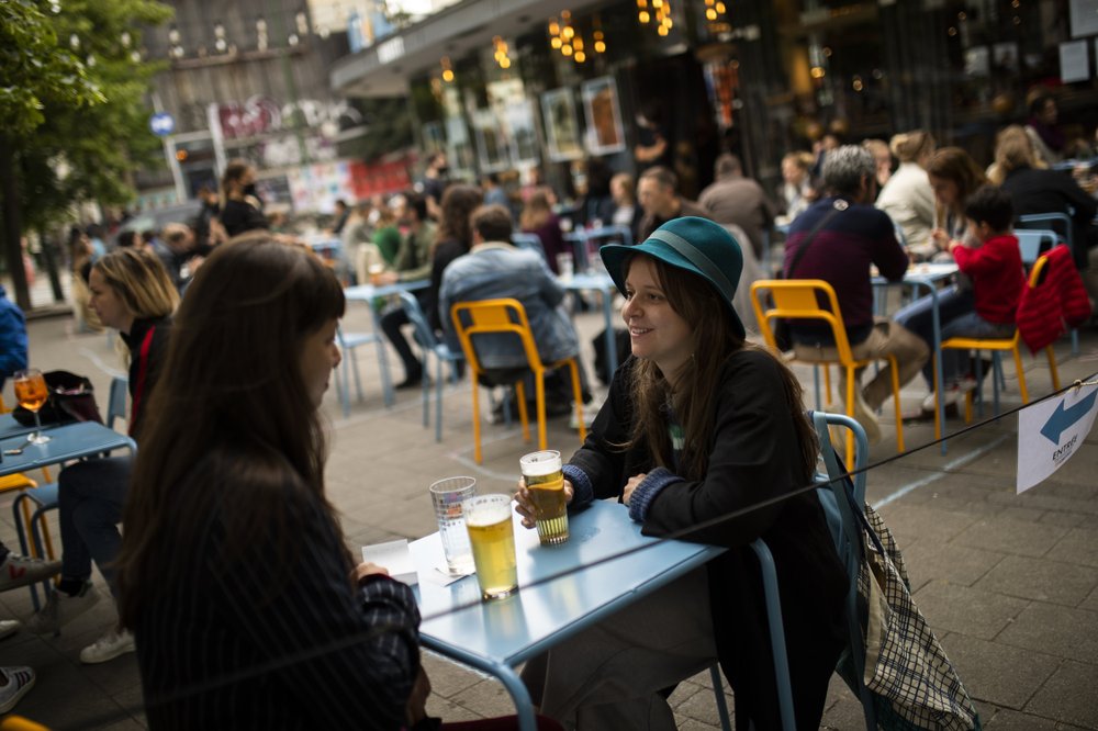 Customers drink beers at the terrace of the Bar du Matin restaurant in Brussels on June 10, 2020. Alex Van Tuijn, co-owner of four cafes in Brussels, has found that staying in business during a pandemic can mean sacrificing some of the very things a company is known for. His Bar du Matin, a stalwart in the nightlife in the Belgian capital city, is no longer serving breakfast and lunch despite the fact “matin” is French for “morning.” (AP)