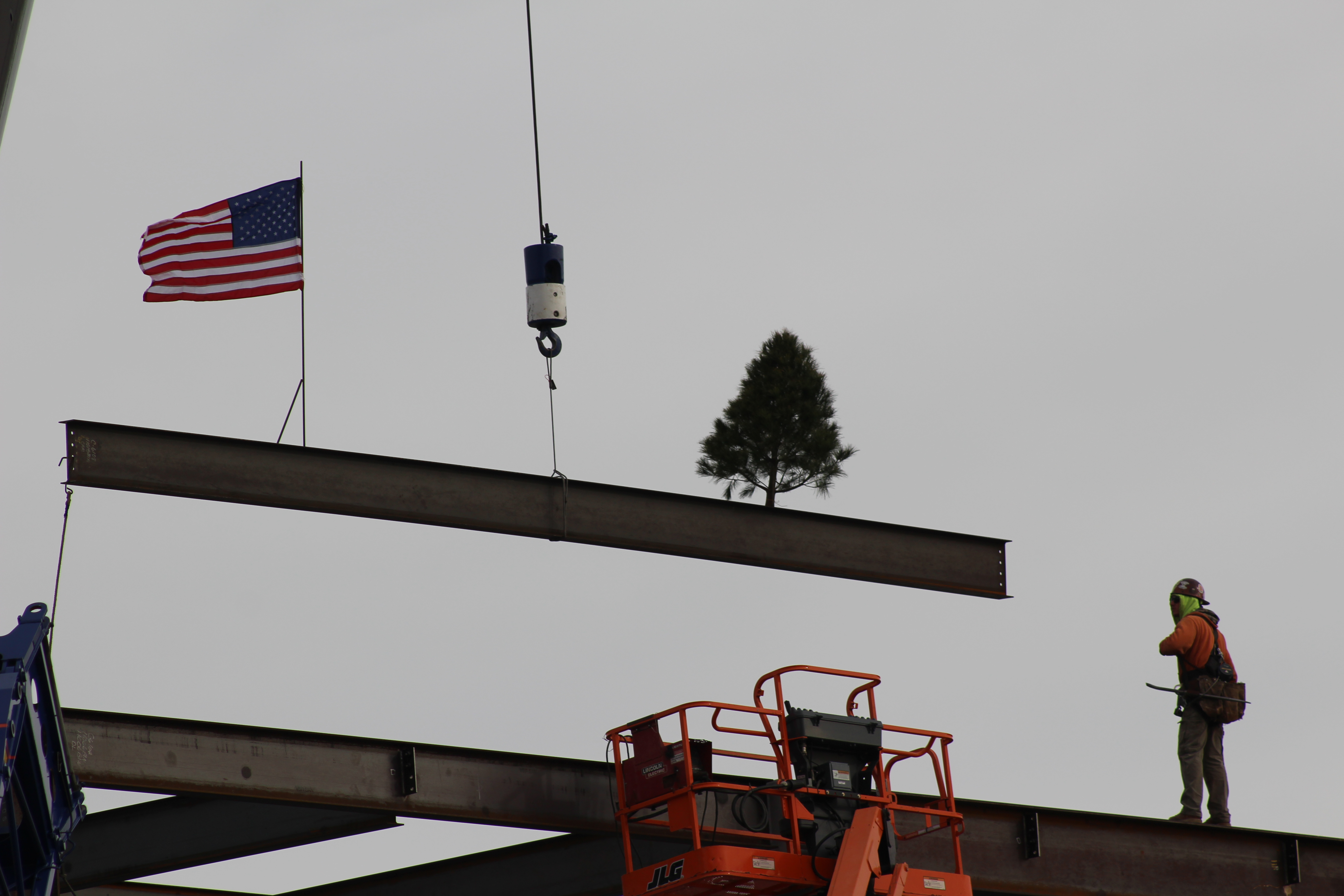 A steel beam is lowered as a construction worker assists in the process at a topping out ceremony for Steelhouse Omaha, Tuesday, Nov. 16. Steelhouse Omaha is a new downtown live music venue expected to be completed in mid-2023, located on the corner of 12th and Dodge streets between the Holland Performing Arts Center and the Capitol District. (Derek Noehren/Daily Record)