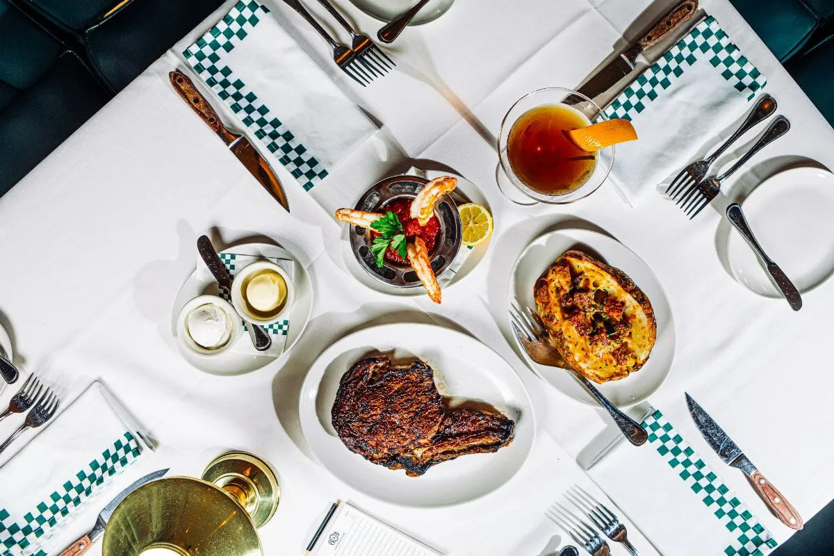 Pictured from top center, the shrimp cocktail, an 801 Manhattan, the loaded baked potato and the wet-aged ribeye, at 801 Chophouse in downtown Omaha.<br />(Joshua Foo / Flatwater Free Press)