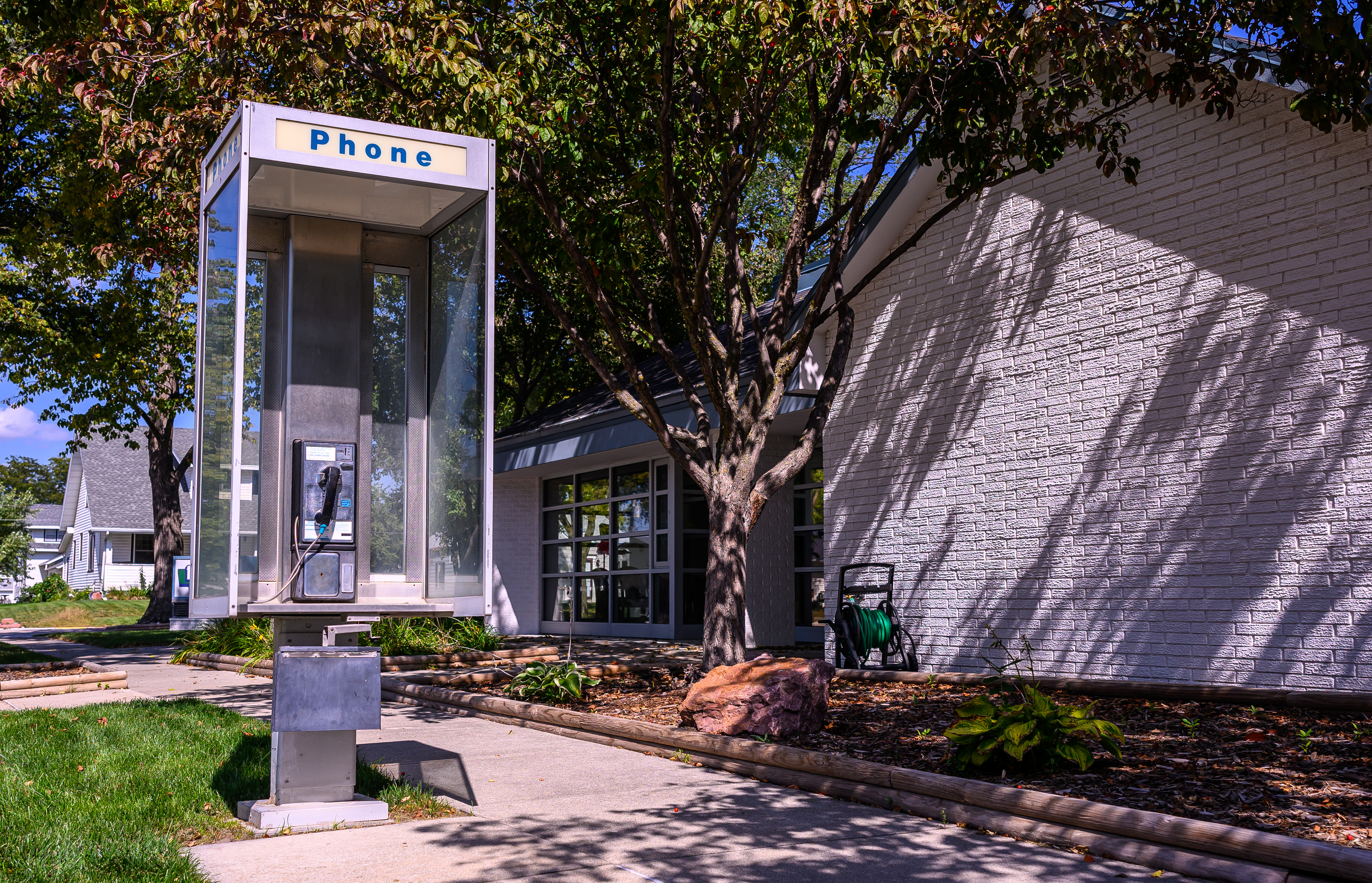 The pay phone outside the Pierce Telephone Co. in Pierce wasn’t working when someone tried to use it, so Jeff Kesting, the phone company’s plant manager, fixed the problem so the phone would work again.<br />(Darin Epperly / Flatwater Free Press)