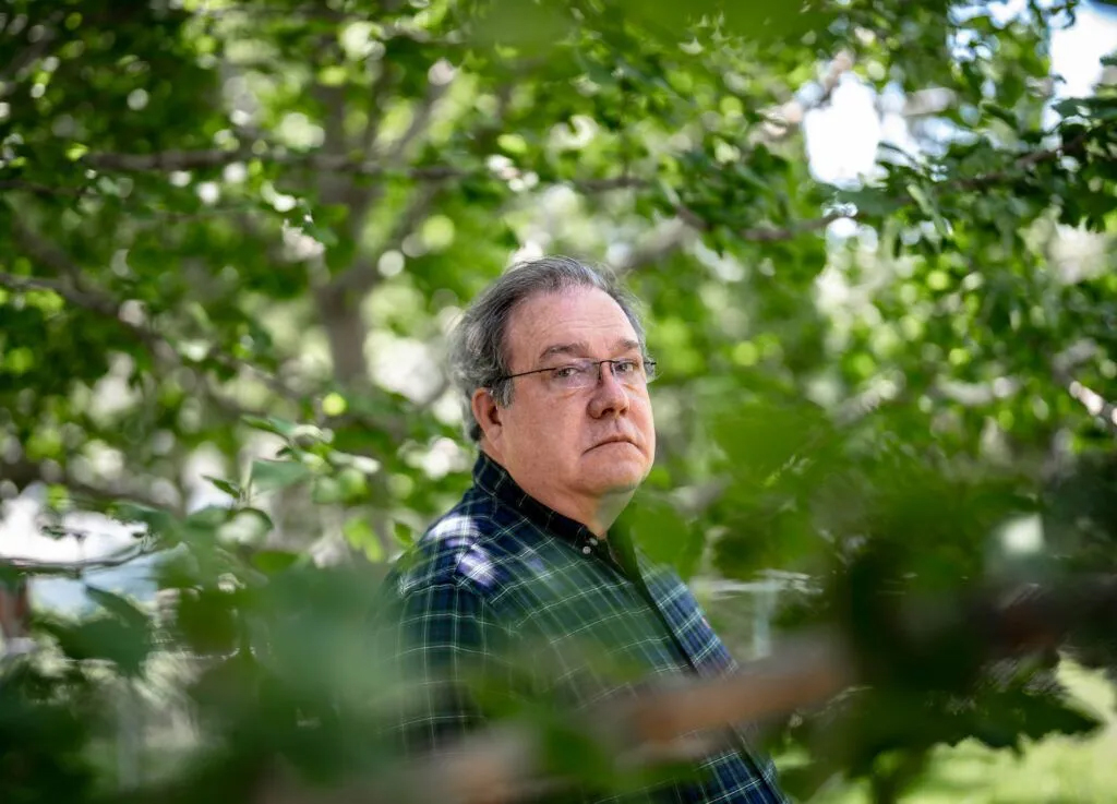 Tim Heller, a mental health advocate and father of a son with a serious mental illness, sits in the backyard of his Omaha home on June 4. Heller, who has filed at least six requests to commit his son, said Nebraska’s mental health system fails families like his by dropping treatment oversight after a person is stabilized.<br />(Abiola Kosoko / Flatwater Free Press)