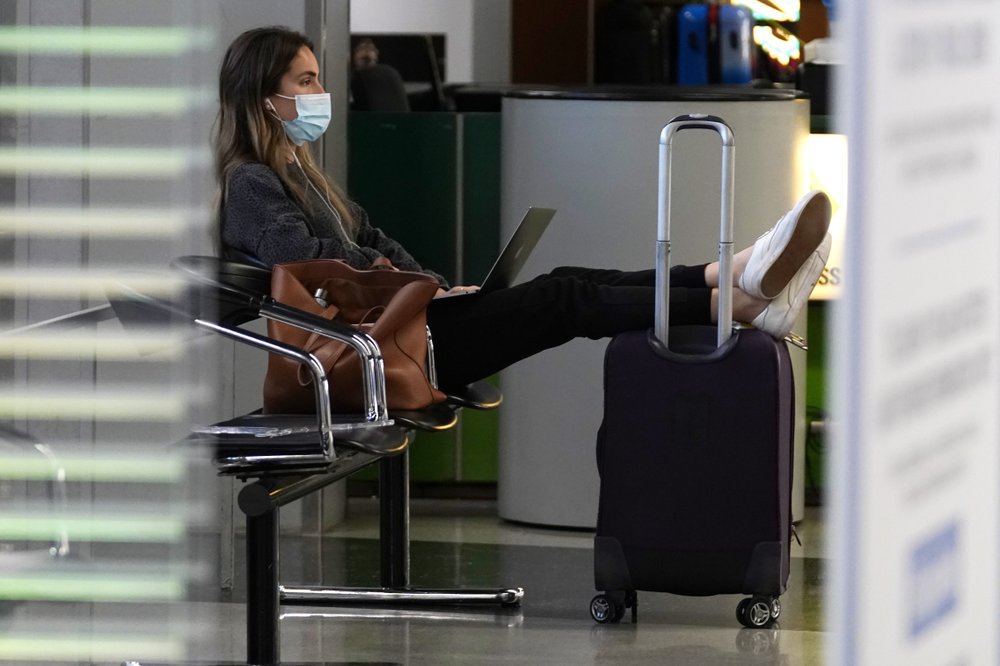 A traveler wears a mask as she waits for her flight in Terminal 3 at O&#039;Hare International Airport in Chicago, Sunday, Nov. 29, 2020. Wall Street recovered after March, even though Main Street is still struggling. As few people traveled, the airline industry needed billions of dollars in aid from the government and is still threatening to lay off workers. (AP)