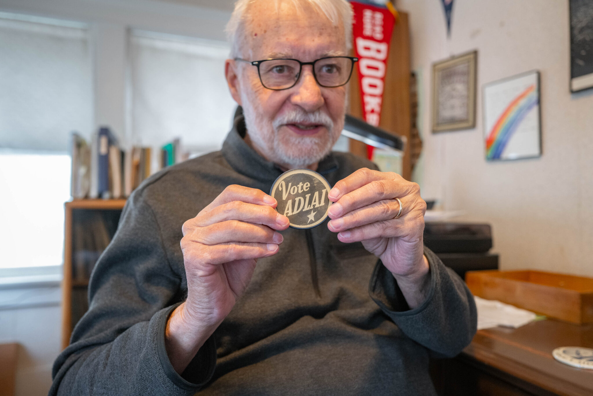 Dave Richardson holds up an Adlai Stevenson campaign button in his Omaha home. As an 8-year-old, he helped his aunt cast a ballot for Stevenson in 1952.<br />(Abiola Kosoko / Flatwater Free Press)