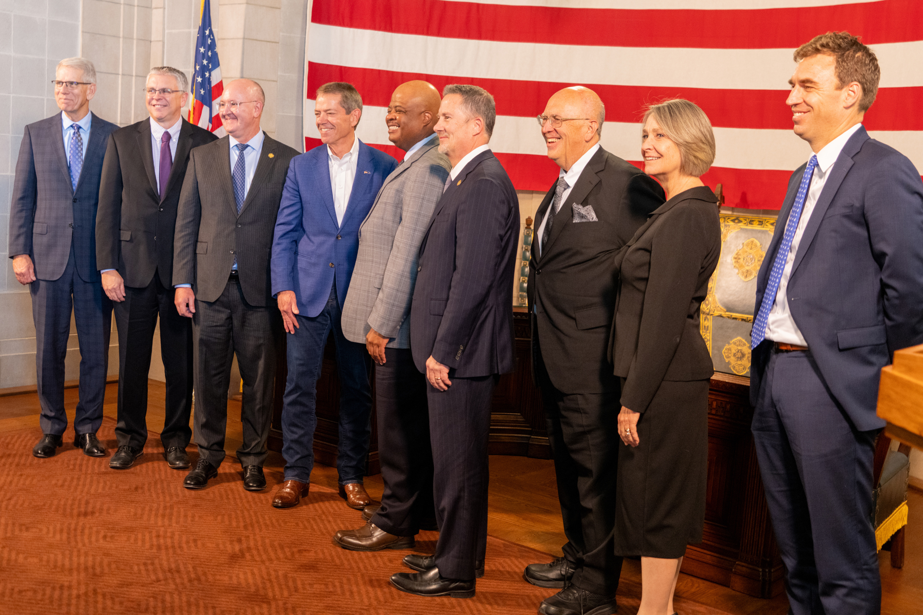 The justices of the Nebraska Supreme Court join Nebraska Gov. Jim Pillen, (center left in a blue suit) and Lt. Gov. Joe Kelly (far left) for the elevation of Douglas County District Judge Derek Vaughn (center) to the Supreme Court. Vaughn’s future colleagues (from left) are Justice John Freudenberg, Jason Bergevin, Jeffrey Funke (chief), William Cassel, Stephanie Stacy and Jonathan Papik, Nov. 10, 2025.<br />(Zach Wendling / Nebraska Examiner)