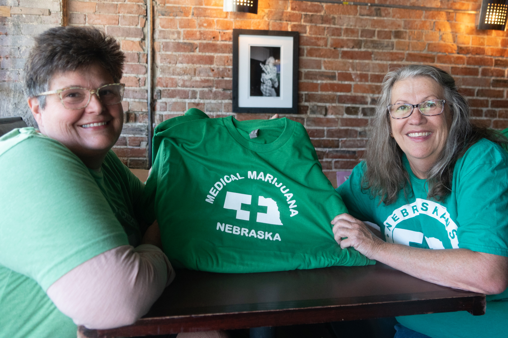 Lia Post (at left) holds a Nebraskans for Medical Marijuana T-shirt beside Trish Petersen on Wednesday, Sept. 13, 2023, on Lincoln, Neb. The two became friends during the campaign.<br />(Zach Wendling / Nebraska Examiner)