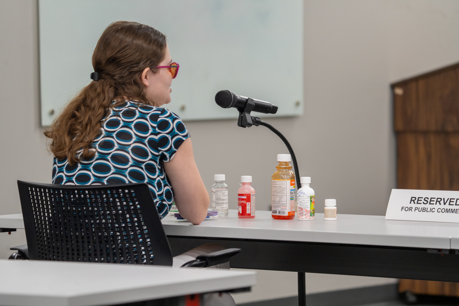 Morgan Ryan of Omaha testifies before the Nebraska Medical Cannabis Commission. Before her are multiple medications she brought to show a variety of flavored meds on Aug 4, 2025.<br />(Zach Wendling / Nebraska Examiner)