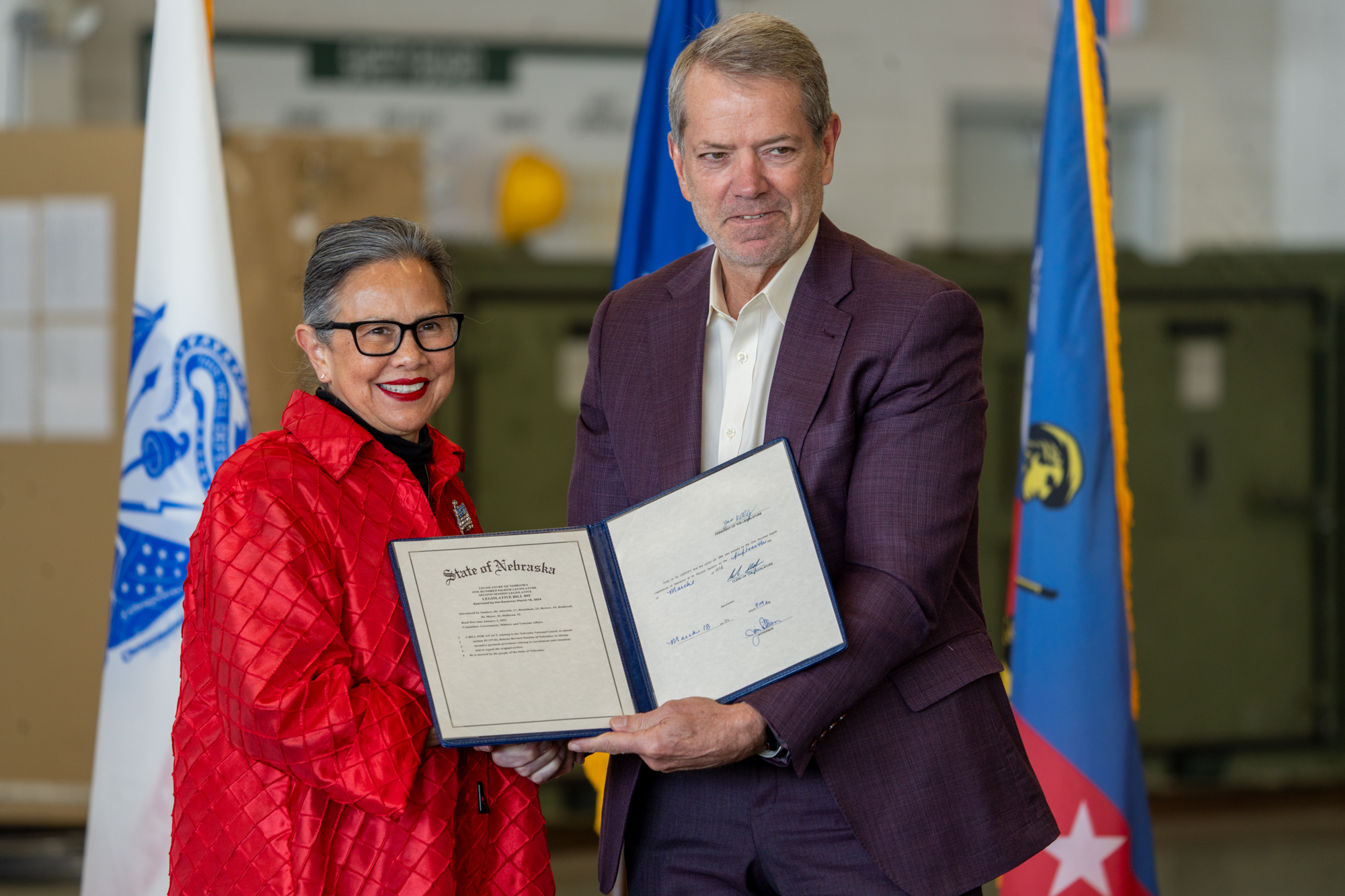 State Sen. Rita Sanders of Bellevue (left) joins Nebraska Gov. Jim Pillen for a ceremonial bill signing of Nebraska National Guard recruitment and retention legislation on Dec. 10, 2024.<br />(Zach Wendling / Nebraska Examiner)