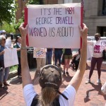 A supporter of Badar Khan Suri holds a sign saying "It's the 1984 George Orwell Warned Us About!," while attending a rally in opposition to the Georgetown University scholar's arrest and detention, outside of the courthouse, at the Federal District Court for the Eastern District of Virginia, in Alexandria, Va., Thursday, May 1, 2025. 
(Jacquelyn Martin / AP Photo)