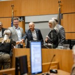 The five members of the Sarpy County Board of Commissioners shake hands with a member of the county sheriff’s department at a board meeting on June 24. From left to right: Gary Mixan, David Klug, Jim Warren, Angi Burmeister and Don Kelly. 
(Abiolo Kosoko / Flatwater Free Press)
