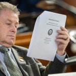 State Sen. Stan Clouse of Kearney reads the voter initiative packet from 2022 that led to voter-approved increases to the state’s minimum wage, March 31, 2025. 
(Zach Wendling / Nebraska Examiner)