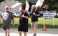 Striking Premier-Midwest Beer & Beverage workers walk the picket line outside the company's west Omaha distribution center. 
(Lily Smith / Flatwater Free Press)
