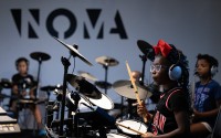 Ava Hardy, 7, learns to play drums during a summer camp at North Omaha Music & Arts in Omaha. 
(Rebecca S. Gratz / Flatwater Free Press)