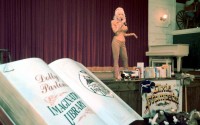 Singer Dolly Parton speaks at her Dixie Stampede Dinner & Show theater in Myrtle Beach, S.C., Thursday, April 11, 2002. Parton, with young children in the audience, said in Myrtle Beach that her Imagination Library book program for preschoolers was coming to South Carolina's Grand Strand. The program, sponsored locally by Parton's Dixie Stampede dinner theater, would provide a free book each month to every child younger than five in Horry County. 
(Lou Krasky / AP Photo)