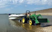Tower Harbor Marina owner Bill Barrow uses a tractor on a newly made rock boat ramp to lower Doug Vollmers boat Thursday afternoon, Aug. 31, 2006, into Kanopolis Reservoir in Kanopolis, Kan. 
(Sandra J. Milburn / The Hutchinson News via AP )