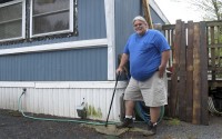 Todd Alexander poses at his mobile home in Milton, Vt., that he heats with the help of the Low Income Heating Home Energy Assistance Program. Alexander, who is disabled and living on disability, said the assistance has helped him meet his energy needs and still have money left over to live. 
 (Wilson Ring / AP Photo)