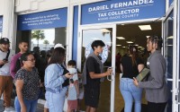 Customer Service representative Marlon Suarez (right) monitors the doorway outside of a Miami-Dade County Office of the Tax Collector Tuesday, May 6, 2025, in Miami. 
(Lynne Sladky / AP Photo)
