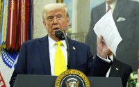 President Donald Trump holds a document with notes about Kilmar Abrego Garcia as he speaks with reporters in the Oval Office of the White House, April 18, 2025, in Washington.
(Alex Brandon / AP Photo)