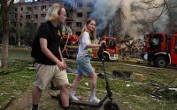 People walk past a smoldering residential building destroyed by a Russian strike in the Lukianivka neighbourhood of Kyiv, Ukraine, on Sunday, May 24, 2026. 
(Evgeniy Maloletka / AP Photo)