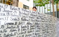 Dawson Kelly holds a banner with names of young people who advocates say died as a result of social media at a protest outside the Ronald V. Dellums Federal Building and U.S. Courthouse on Tuesday, Aug. 18, 2026, in Oakland, Calif. 
(Noah Berger / AP Photo)