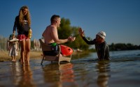 Ukrainian war veteran Maxim Yuzvyak (center) is greeted by sport celebrity Danylo Sapunov during a sporting event to encourage people and injured soldiers to take part in sports at a lake on the outskirts of Kyiv, Monday, Aug. 24, 2026.
(Francisco Seco / AP Photo)
