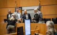The five members of the Sarpy County Board of Commissioners shake hands with a member of the county sheriff’s department at a board meeting on June 24. From left to right: Gary Mixan, David Klug, Jim Warren, Angi Burmeister and Don Kelly. 
(Abiolo Kosoko / Flatwater Free Press)