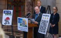 Eric Underwood, former chair of the Nebraska Republican Party (center) leads a news conference with his new nonprofit Advocates For All Nebraskans to announce two ballot measures intended to lower property taxes and cap annual increases to property valuations, Aug. 25, 2025. 
(Zach Wendling / Nebraska Examiner)
