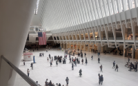 Two large American flags hang within The Oculus in the World Trade Center in downtown Manhattan on September 11, 2026. 
(Shalina Chatlani / Stateline)
