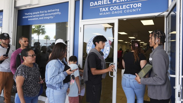 Customer Service representative Marlon Suarez (right) monitors the doorway outside of a Miami-Dade County Office of the Tax Collector Tuesday, May 6, 2025, in Miami. 
(Lynne Sladky / AP Photo)