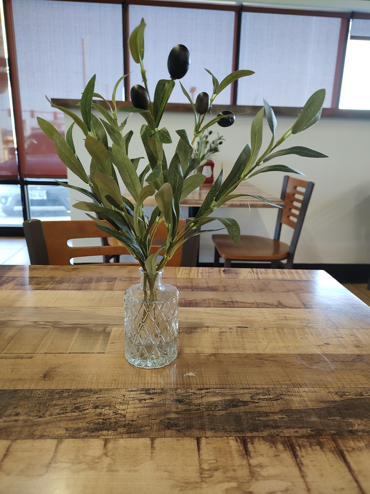 Such a well-placed olive branch on a gorgeous wooden table, lending to Zaytuna&#039;s pleasant aesthetic. <br />(Austin Petak / The Daily Record)
